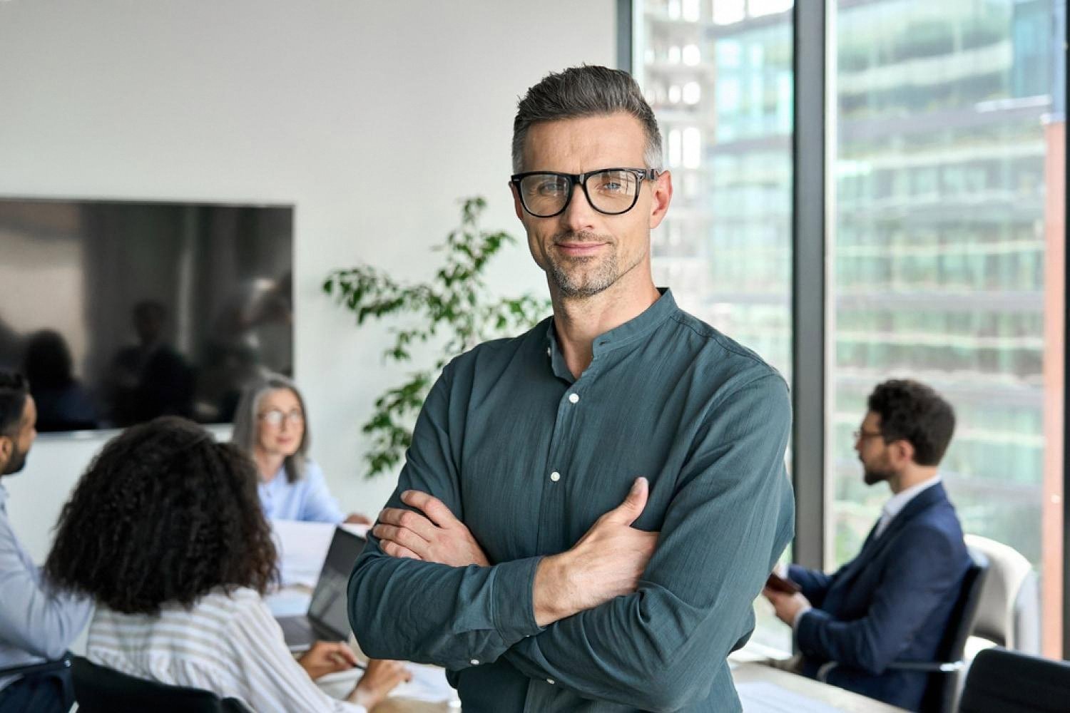 Confident manager standing in front of a diverse team working together in a modern UAE office